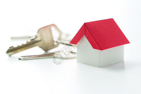 白色背景上的微型红房子和门钥匙图片