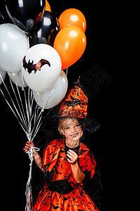 穿着神圣的装扮巫婆拿着气球在黑图片