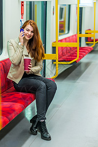 这个女孩在空荡的地铁车厢里用手机说话女孩坐在地铁车里图片
