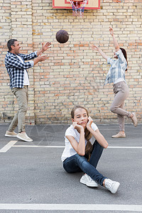 心烦意乱的女儿快乐的父母在后面打篮球图片
