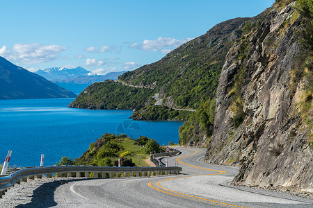 在新西兰南岛皇后镇沿山悬崖和湖泊地貌环绕而行的道路图片