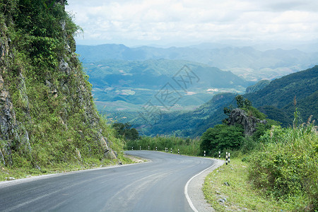 和长风农村道路通过老挝的绿山背景图片