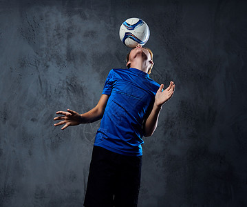 穿蓝制服的足球运动员和球一起打球他图片
