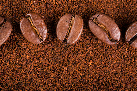 在白色背景中分离出的烤咖啡豆烤咖啡豆背景关闭咖啡豆堆在咖啡粉的背景上背景图片