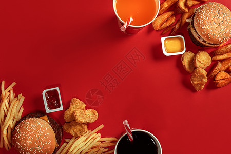 汉堡和薯条红纸盒中的汉堡包和炸薯条红色背景上的快餐汉堡配番茄酱顶视图图片