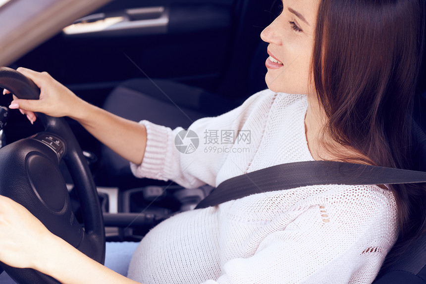 以安全带驾驶车紧贴怀孕的快图片