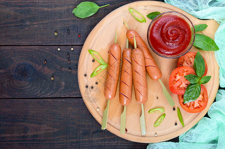 用番茄酱和新鲜西红柿串起来的香肠图片