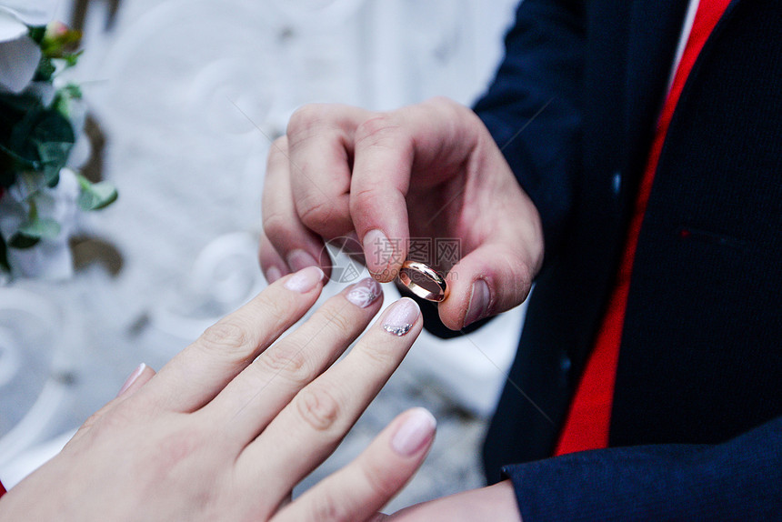 新郎把戒指戴在新娘手上照片贴近的婚礼戒图片