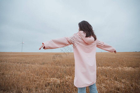 穿粉红色雨衣的黑发女孩站在图片