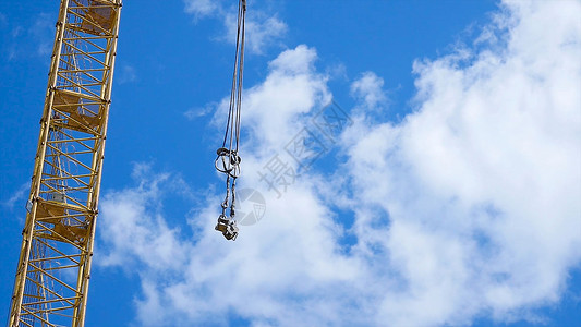 变幅关闭一个黄色和绿色起重机吊臂与主块和吊臂反对清澈的蓝天对着天空的塔背景