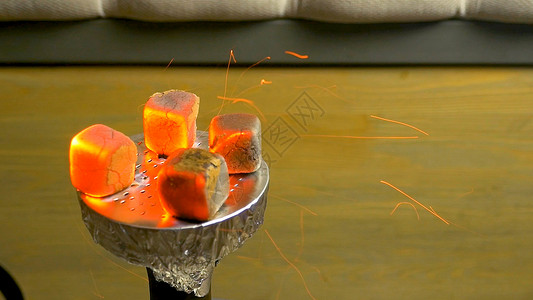 燃烧的煤水烟产生的火花碗里的水烟草炽热的红椰子木炭通过将木炭放在HD上背景图片