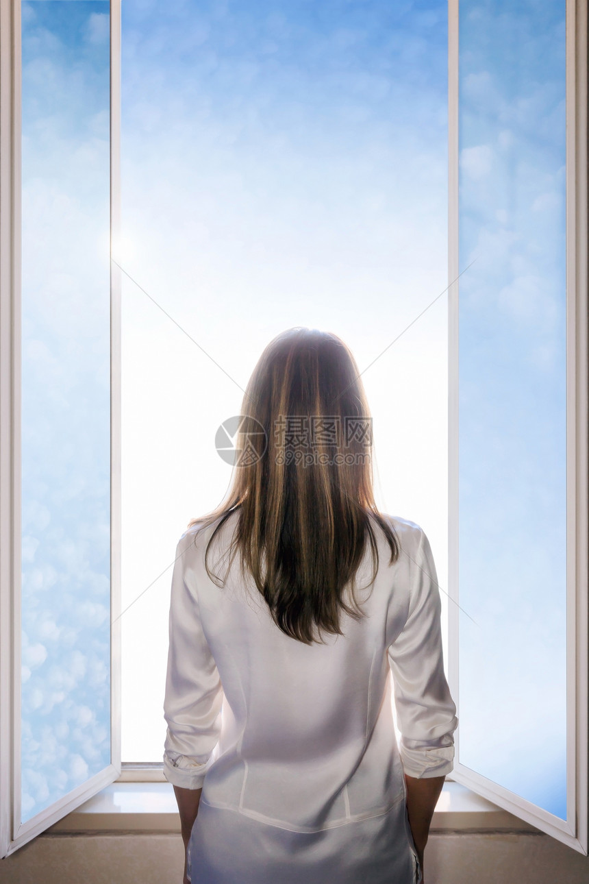 一个长发和摇摆的女人她打开窗门让灯光进入房间云层天空图片