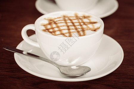 咖啡店餐桌上白杯热焦糖咖啡图片