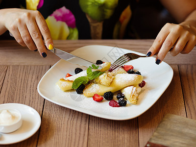 一个女孩用叉子和刀子吃水果图片