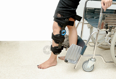 支持膝部扶助的病人尝试步行训图片