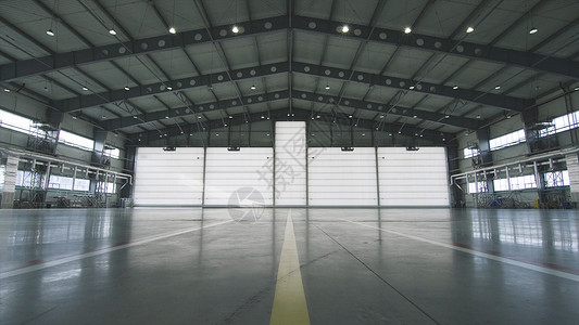 工业背景的厂房内的卷帘门和混凝土地板前面的飞机半开到机库的门机库敞开的门背景图片