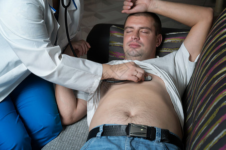 一位女医生在他家听病人的胸部图片