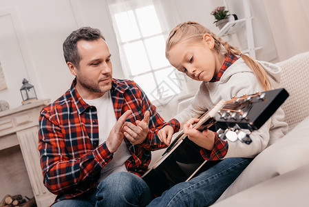 当可爱的小女儿弹吉他时图片
