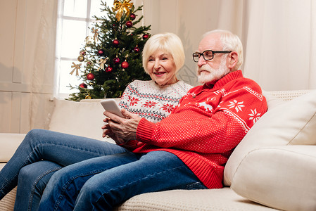 幸福的老年情侣在家使用智能手机图片