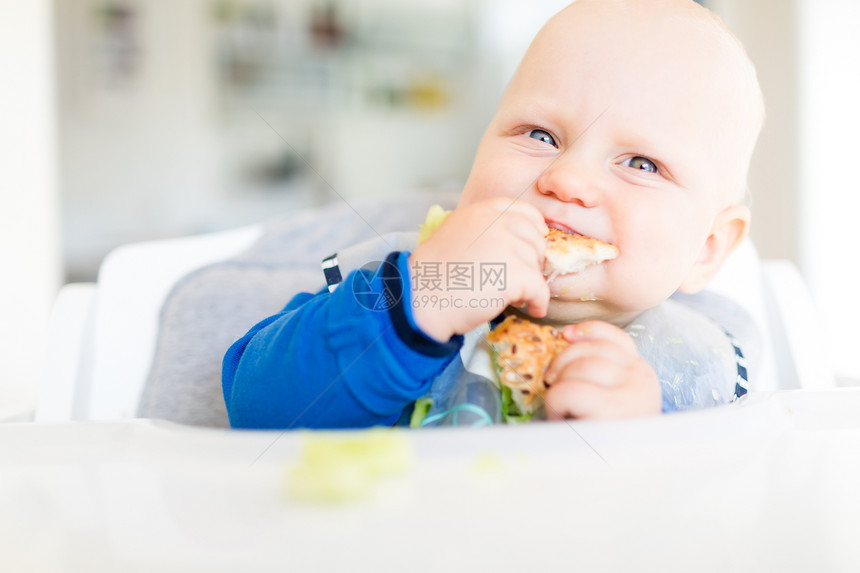 男婴用BLW方法吃面包和黄瓜图片
