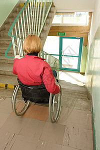 坐在轮椅上的残疾妇女试图在楼图片