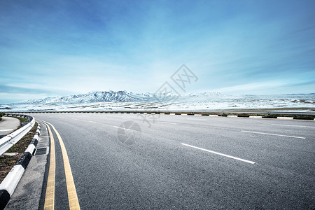 空旷的柏油路和蓝天中的雪山图片