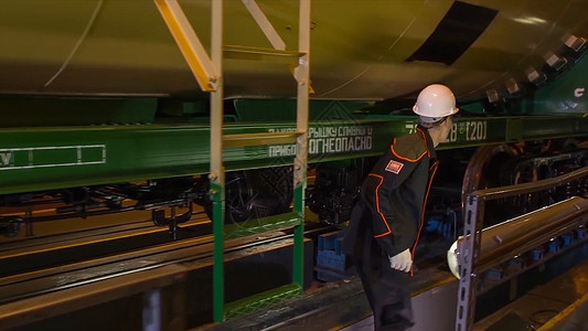 火车制造厂的工人工厂的工人检查火车厢工厂员工检查生产中的火车厢货图片