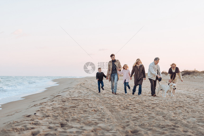 家人手牵在海边图片