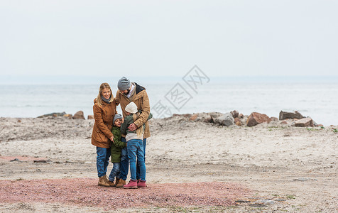 寒秋日海边拥抱的美好家庭图片