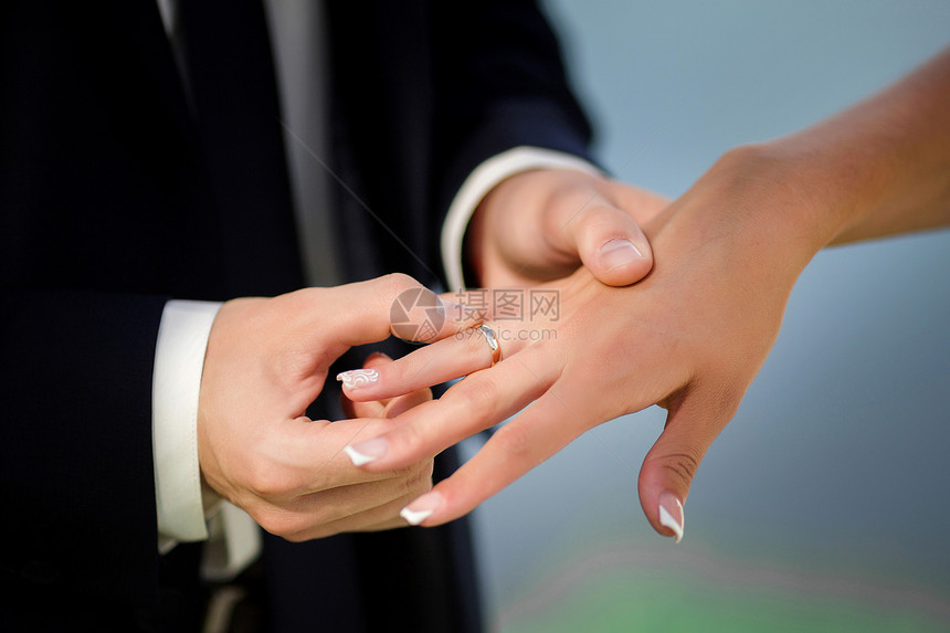 新郎将戒指戴在新娘身上图片