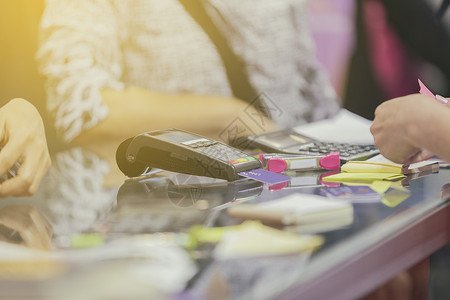 亚洲商业妇女使用信卡打扫机在自助食堂和超市付款图片