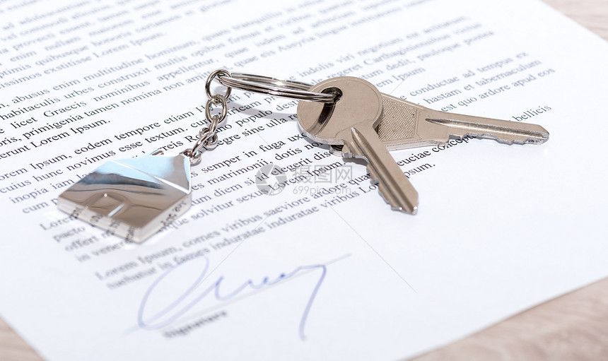 已签署合同上的房屋钥匙特写图片