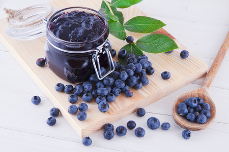 白色木桌上的蓝莓果酱和新鲜水果图片