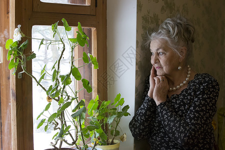 窗口的老美丽的妇女一个非常老妇人一个八十多岁的女人一位老妇人的工作室肖像孤独的背景图片