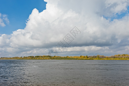 在河岸对面的风景雨云下以秋色森林为秋图片