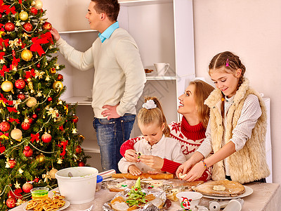 圣诞家庭晚餐为孩子们在圣诞厨房里为圣诞派对滚动面团男人正在家图片
