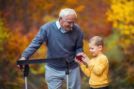年轻孙子在公园里给残疾的老爷打电图片