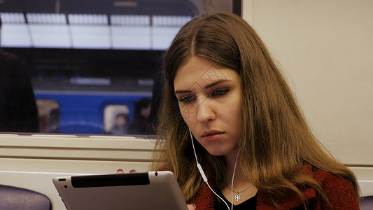 年轻的女商人旅行火车平板电脑地铁里的年轻女子在平图片