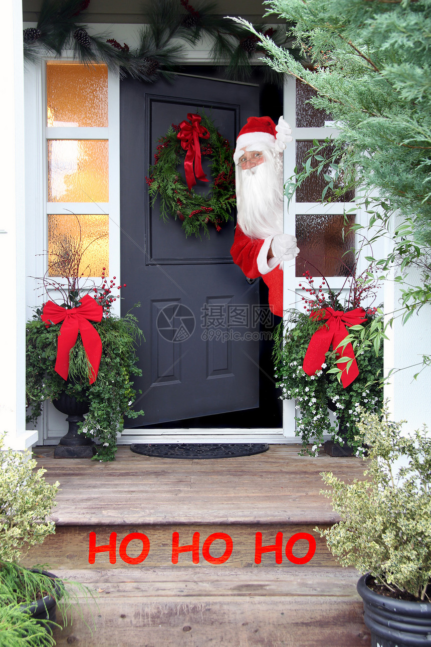 圣诞老人看着房子的门外美丽地装饰了图片