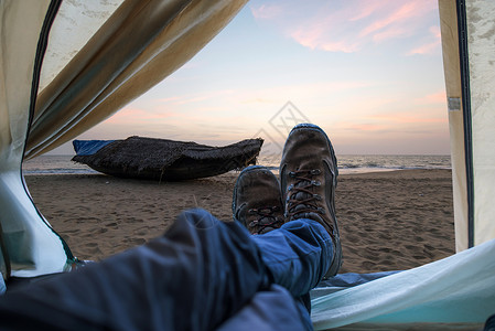 海边沙滩上的帐篷和日落时的船景野外旅行和探险图片