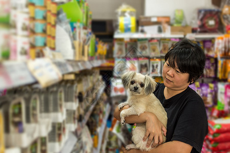 妇女和她的狗店在宠物店的宠物货架上购买宠物食品Dog图片