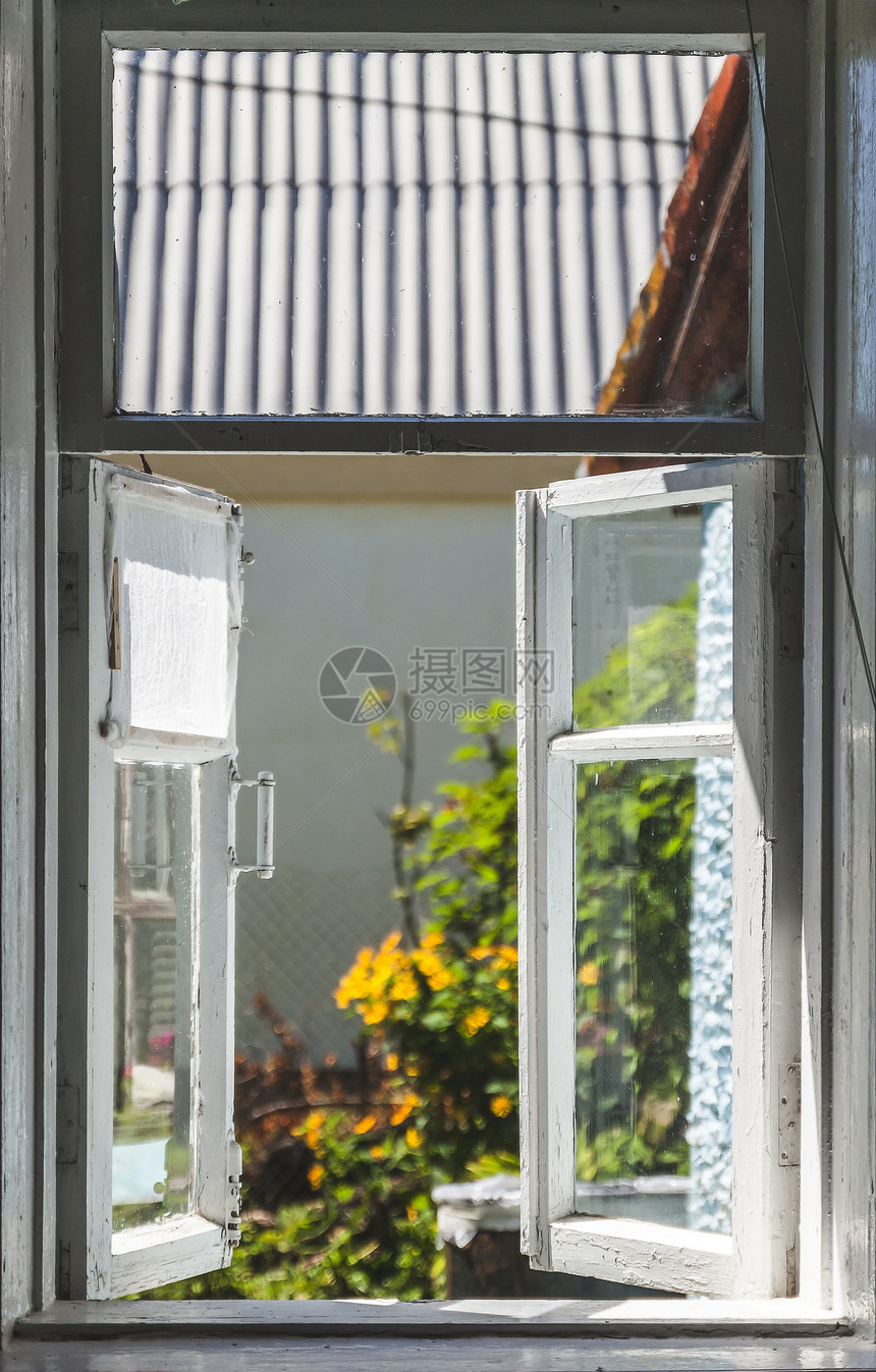 在阳光明媚的夏日庭院里从一个古老的农村窗户图片