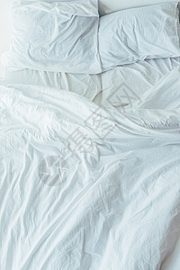 带白色床上用品枕头和毯子的床顶视图图片