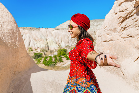 中东沙漠的亚洲女旅行者穿着带有头巾的国图片