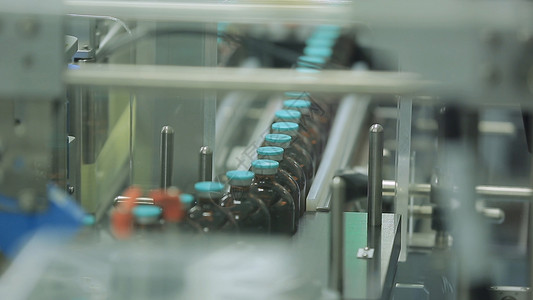 医药行业生产线机器输送机在工厂与瓶子液体药物的制背景图片