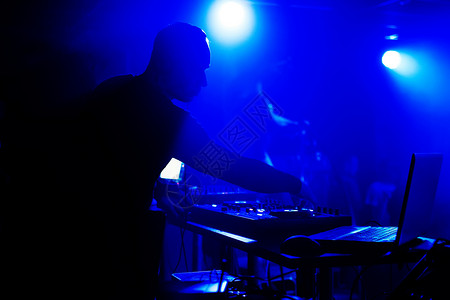 DJ在夜总会演出在活动下蓝灯下在图片