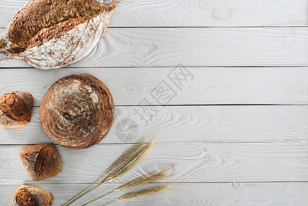 木制桌上的面包和小钉子上方有健康的自图片