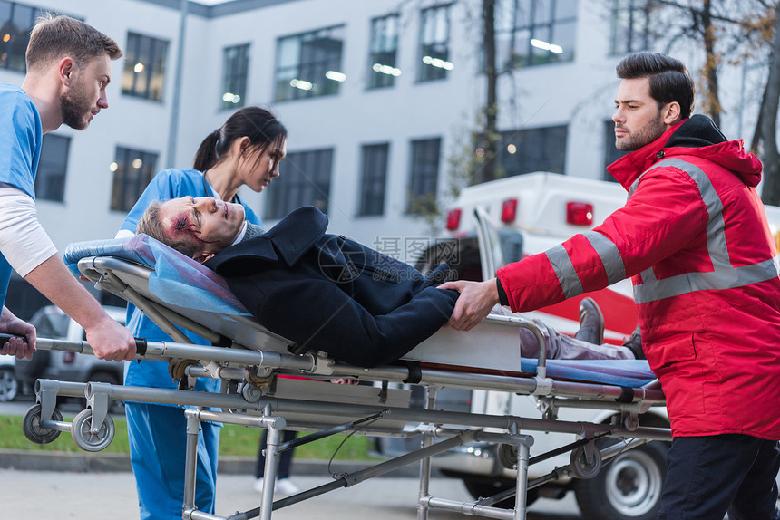 医生在救护车担架上移动受伤的人图片