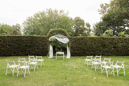 在花园绿草坪上举行婚礼结婚拱门和图片