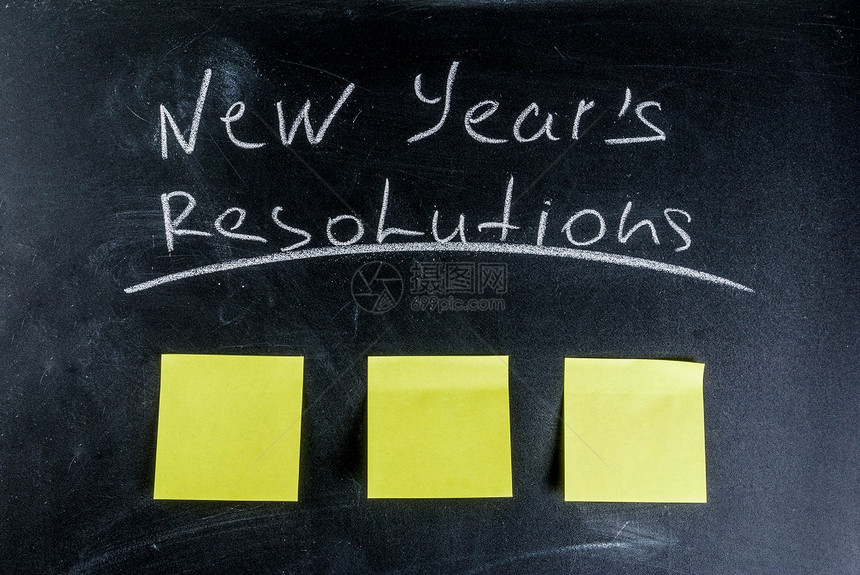 新年决议带粉笔和白纸笔的黑板背图片